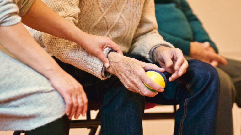 Older adult participating in a meaningful hand activity with support